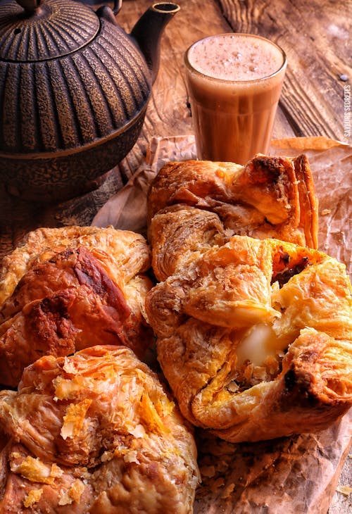 Baked Pastries and a Chocolate Drink on a Wooden Surface