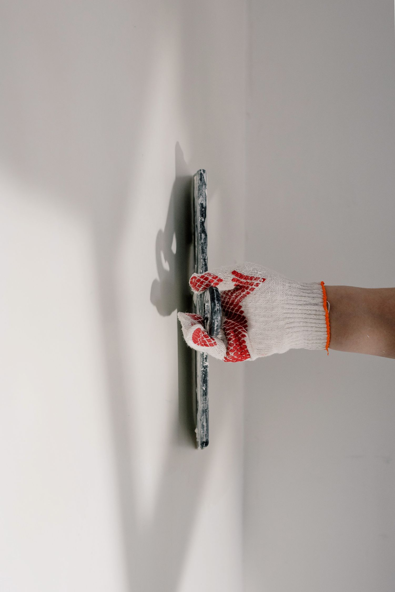 Worker Leveling Walls With Trowel During Repairs Free Stock Photo worker-leveling-walls-with-trowel-during-repairs-free-stock-photo