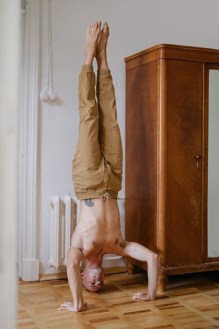 Topless Man Doing A Headstand