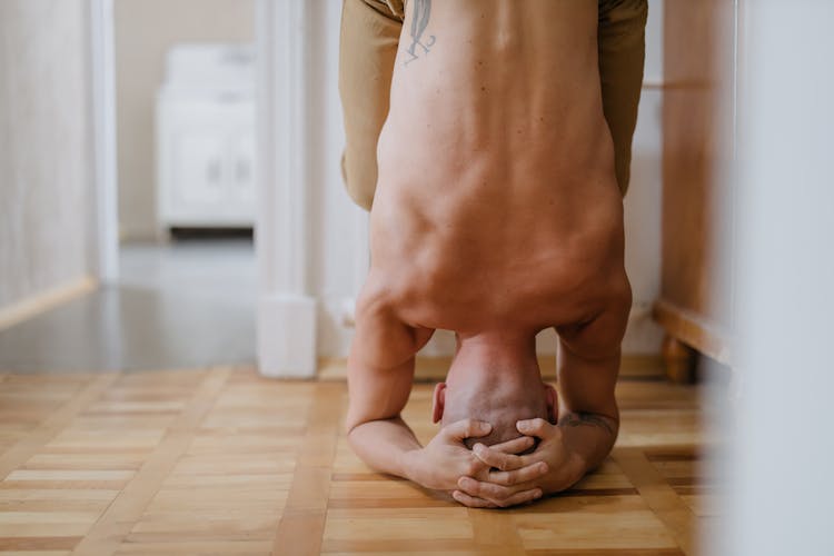 Shirtless Man Doing A Headstand