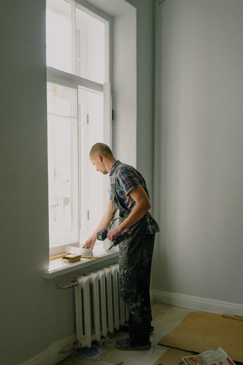 Man with screwdriver preparing for renovation in apartment