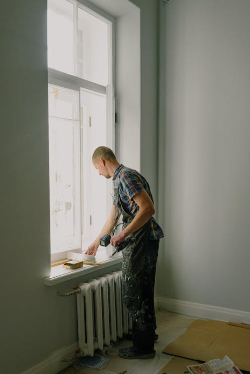 Free Man with screwdriver preparing for renovation in apartment Stock Photo