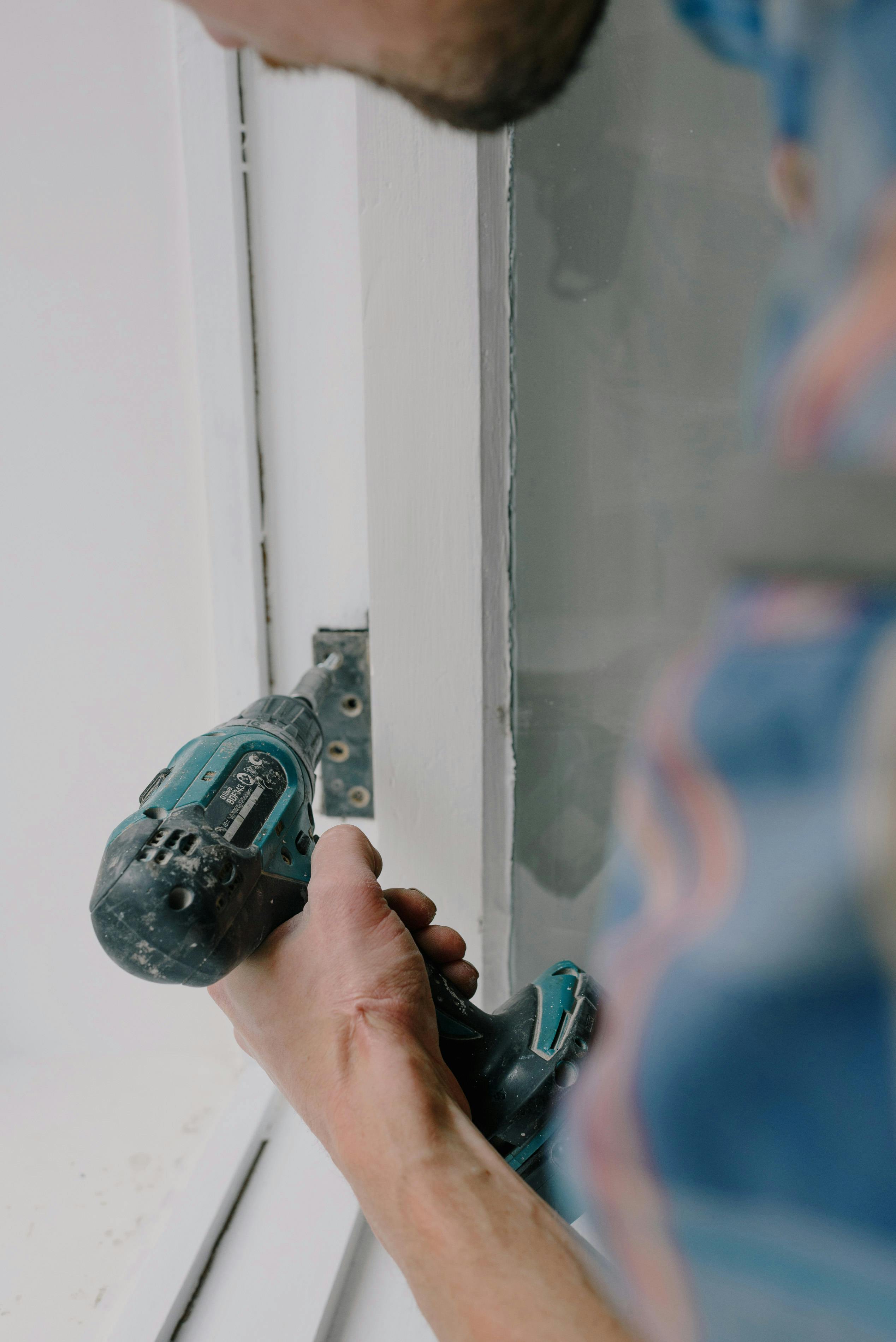 crop man installing window during apartment renovation