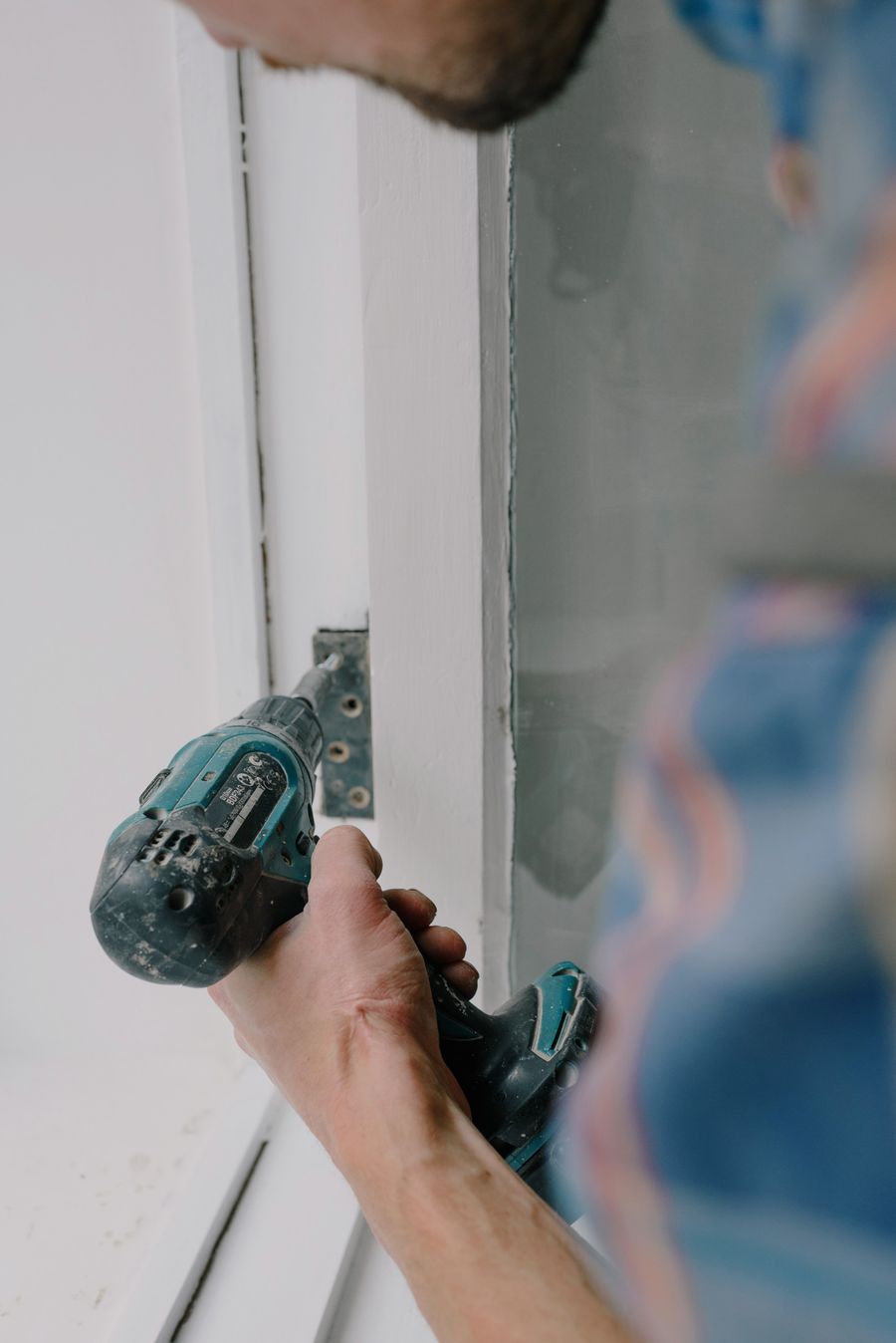 Installer fitting a new impact window frame