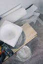 From above of bucket of white paint located under plywood plank with contemporary screwdriver and various materials for renovation