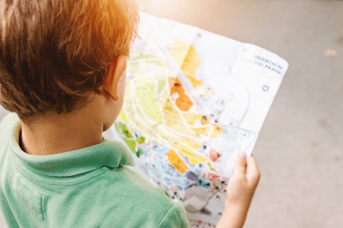 Free Boy Holding Map on Road Stock Photo