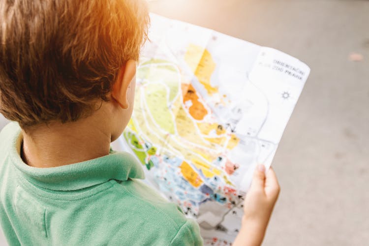 Boy Holding Map On Road