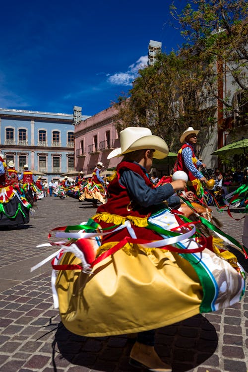 Small Boy in a Colorful Costume Dancing at a Festival on the City Square