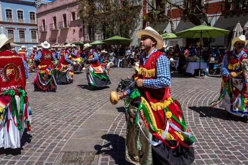 Free Colorful traditional dancers celebrating Mexican heritage in a lively town square. Stock Photo