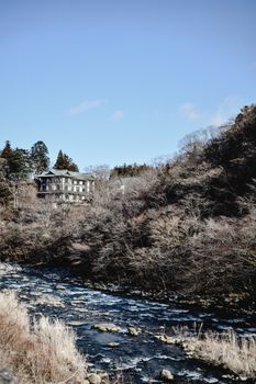 在日本日光，河流静静地流过白雪覆盖的灌木丛，构成一幅宁静的冬日景象