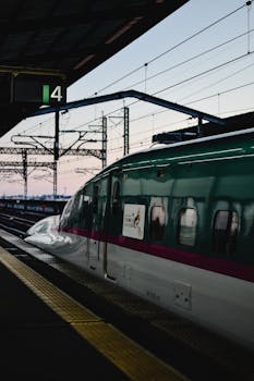 A sleek bullet train at Tokyo Station during a serene evening transition.