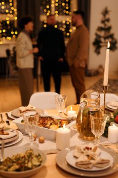 Elegant Christmas dinner setup with candles and holiday decor, creating a cozy atmosphere.