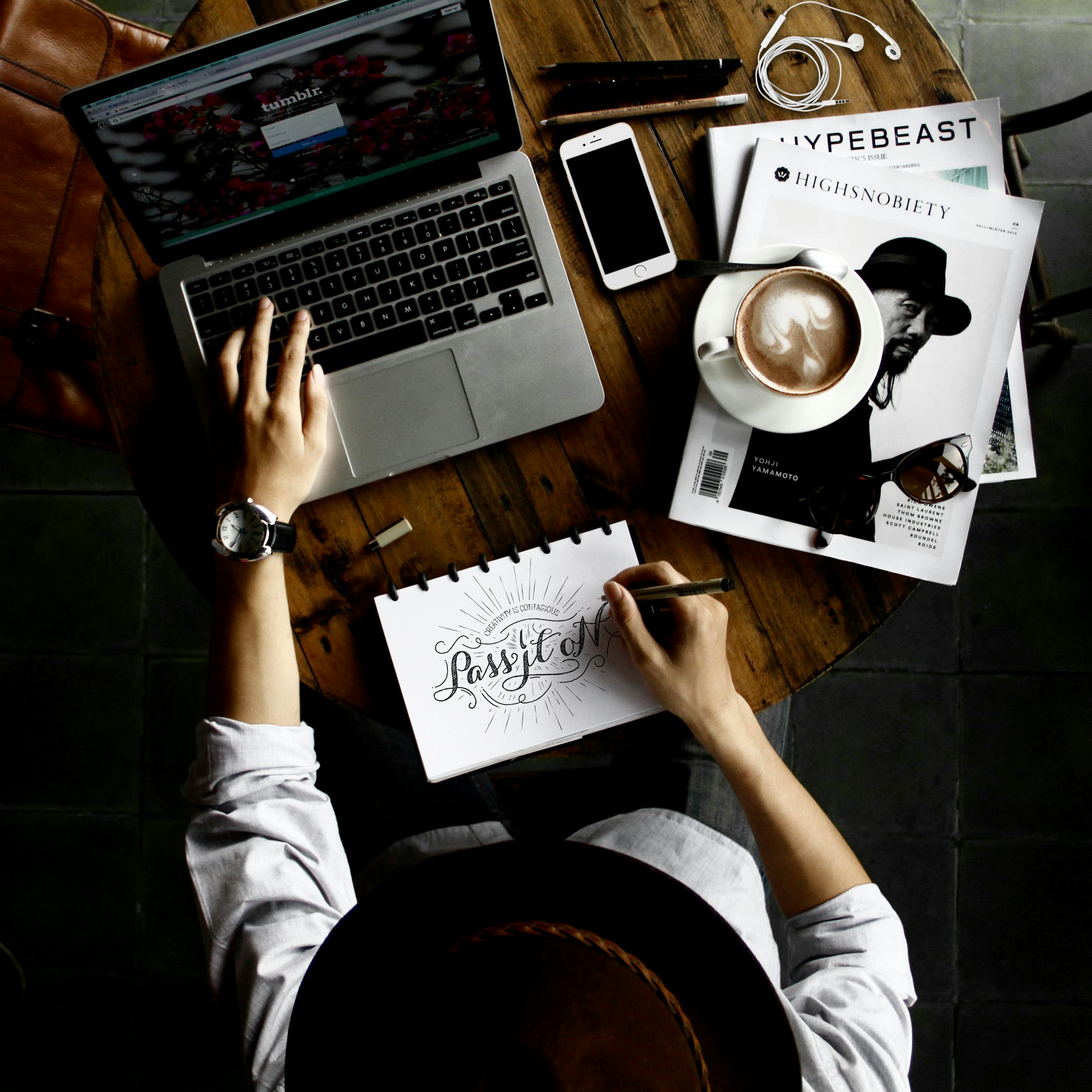 Free Person Sitting Facing Laptop Computer With Sketch Pad Stock Photo