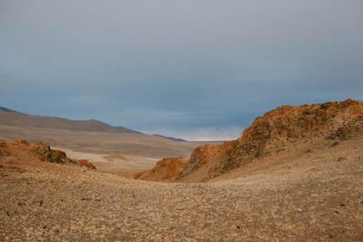 Expansive view of a desert landscape with rocky terrain under a blue sky, capturing natural beauty.