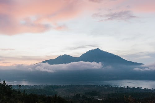 多雲的天空下山附近的綠樹