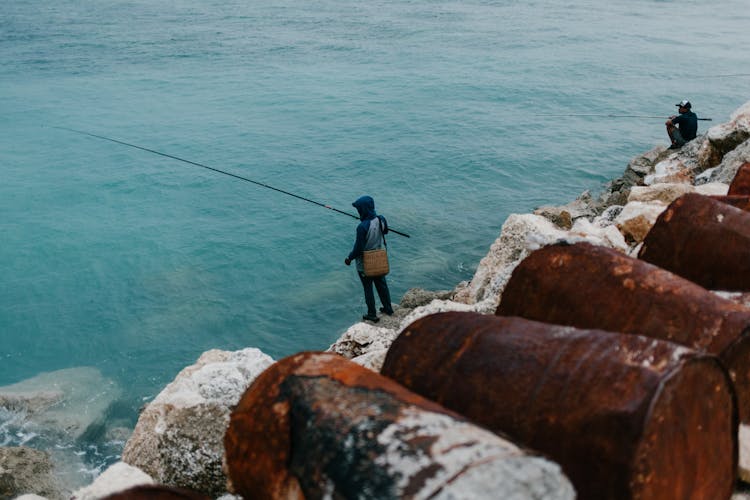 A Man Using Fishing Rod At The Sea