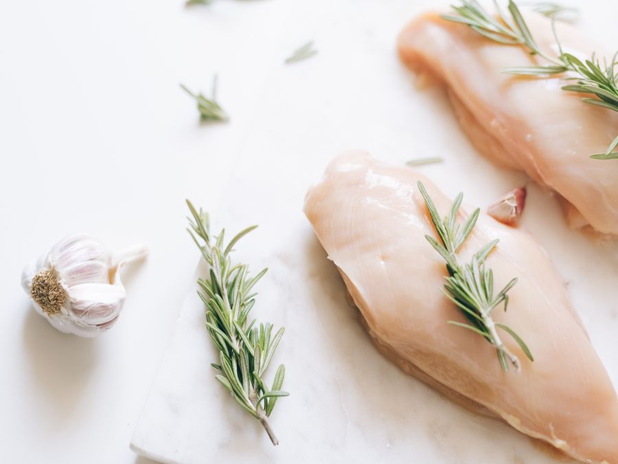 Raw chicken breasts on a white surface