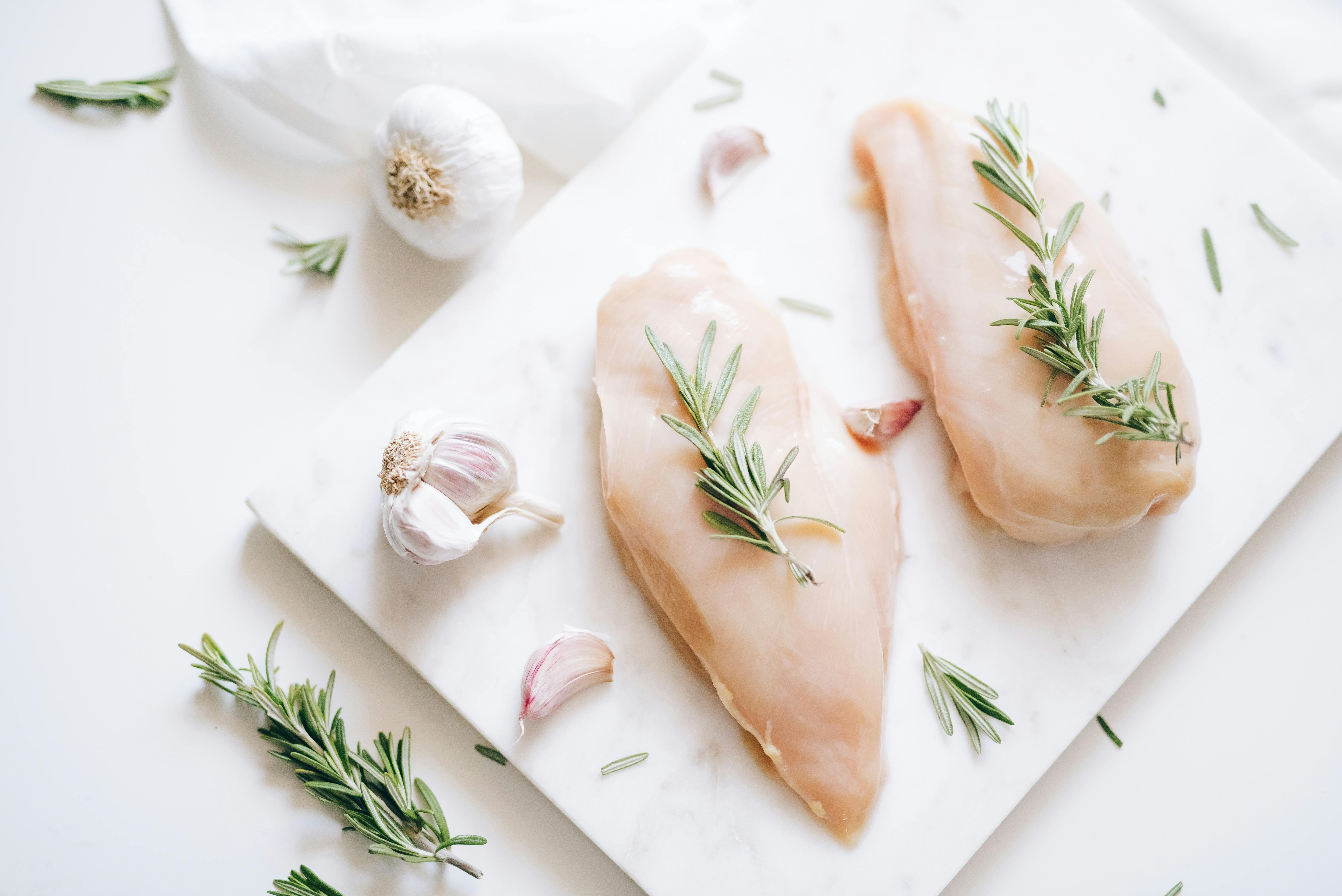 Top View of Rosemary Sprigs on Raw Chicken Breasts · Free Stock Photo