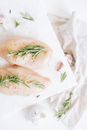 生鸡胸肉顶视图，饰以新鲜迷迭香小枝