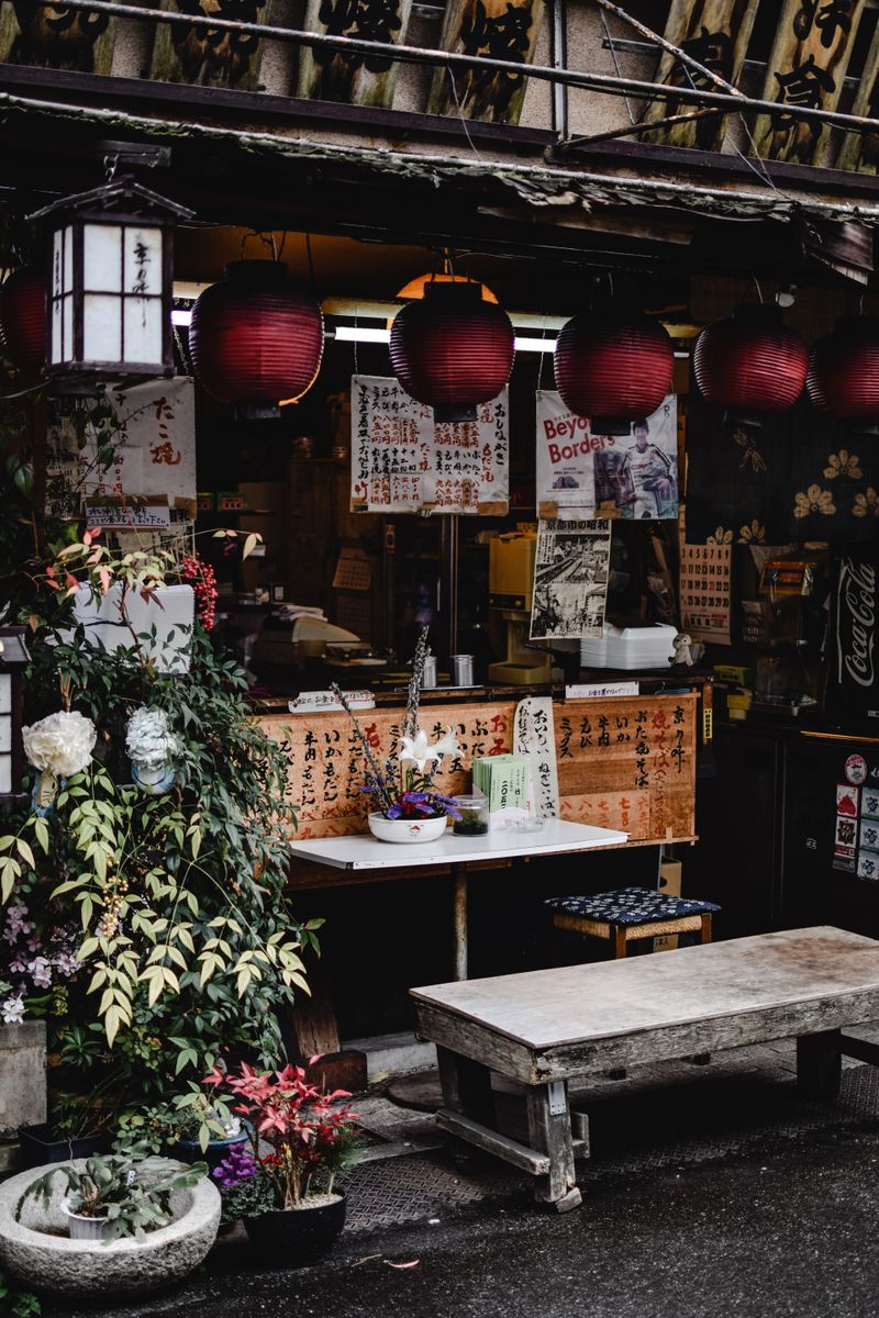 Traditional Japanese market alley with red paper lanterns — the intimate scale of Kanazawa's neighbourhood markets, where local craft, seafood, and sake have been traded for centuries