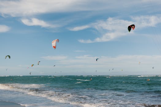 Exciting scene of multiple kite surfers riding ocean waves against a bright blue sky, perfect for sports enthusiasts.
