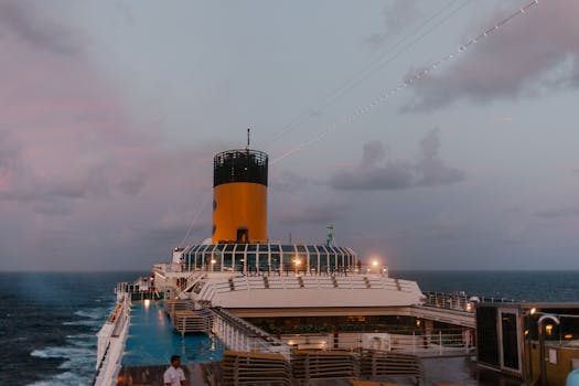 A cruise ship sails peacefully at twilight, with a beautiful ocean backdrop and soft evening lights.