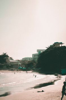 People enjoying a sunny day on a vibrant beach next to the ocean waves.