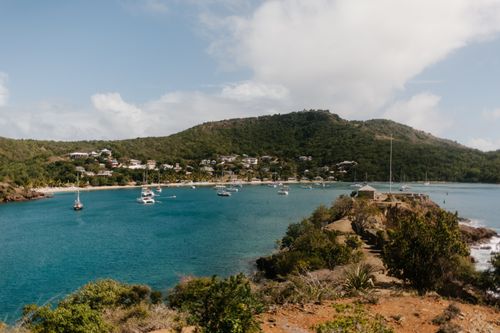 Free Picturesque bay with sailboats anchored near lush island landscape in vibrant summer setting. Stock Photo