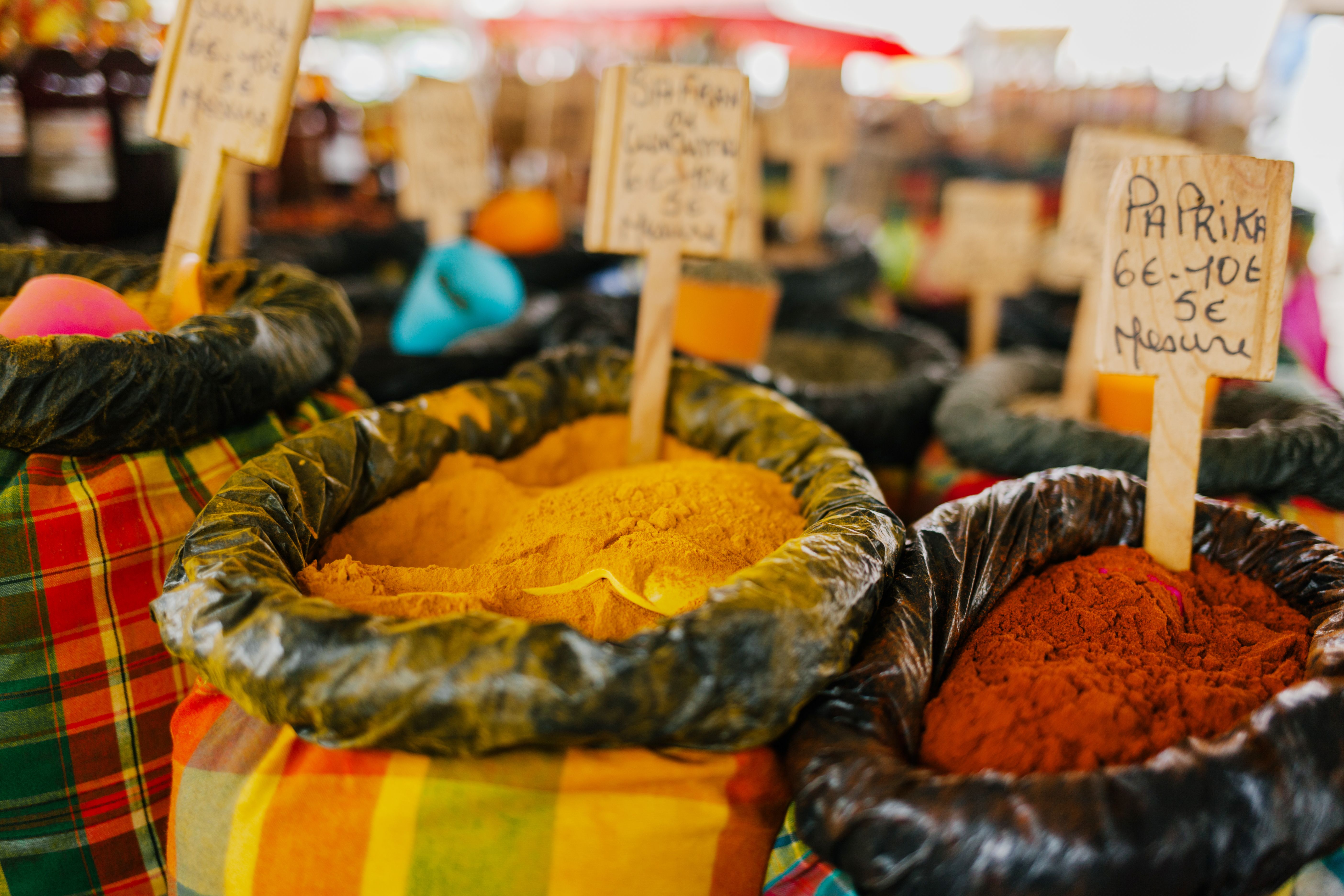 一个充满活力的户外市场上，展出了五颜六色的香料和调味料，其中以辣椒粉及其他多种口味为特色