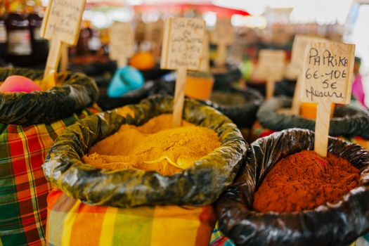 一个充满活力的户外市场上，展出了五颜六色的香料和调味料，其中以辣椒粉及其他多种口味为特色
