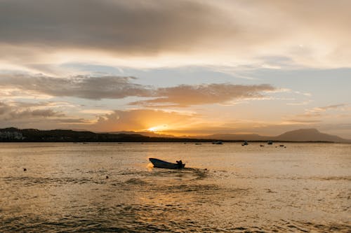 Silhouette De Personne à Cheval Sur Le Bateau Sur La Mer Pendant Le Coucher Du Soleil