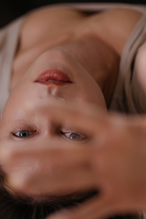 Close-up Shot of a Woman Covering Her Face Using Her Hand