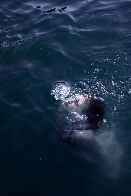 Fotomural Retrato artístico submarino de una mujer sumergida, capturando burbujas de aire y expresiones serenas.