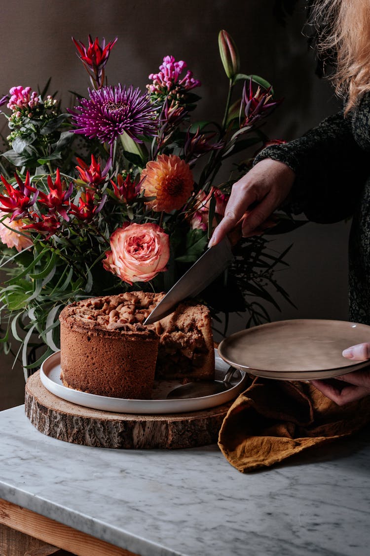 Person Holding Knife Cutting A Chocolate Cake