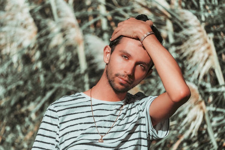 Close-Up Shot Of A Man In Striped Shirt Brushing His Hair