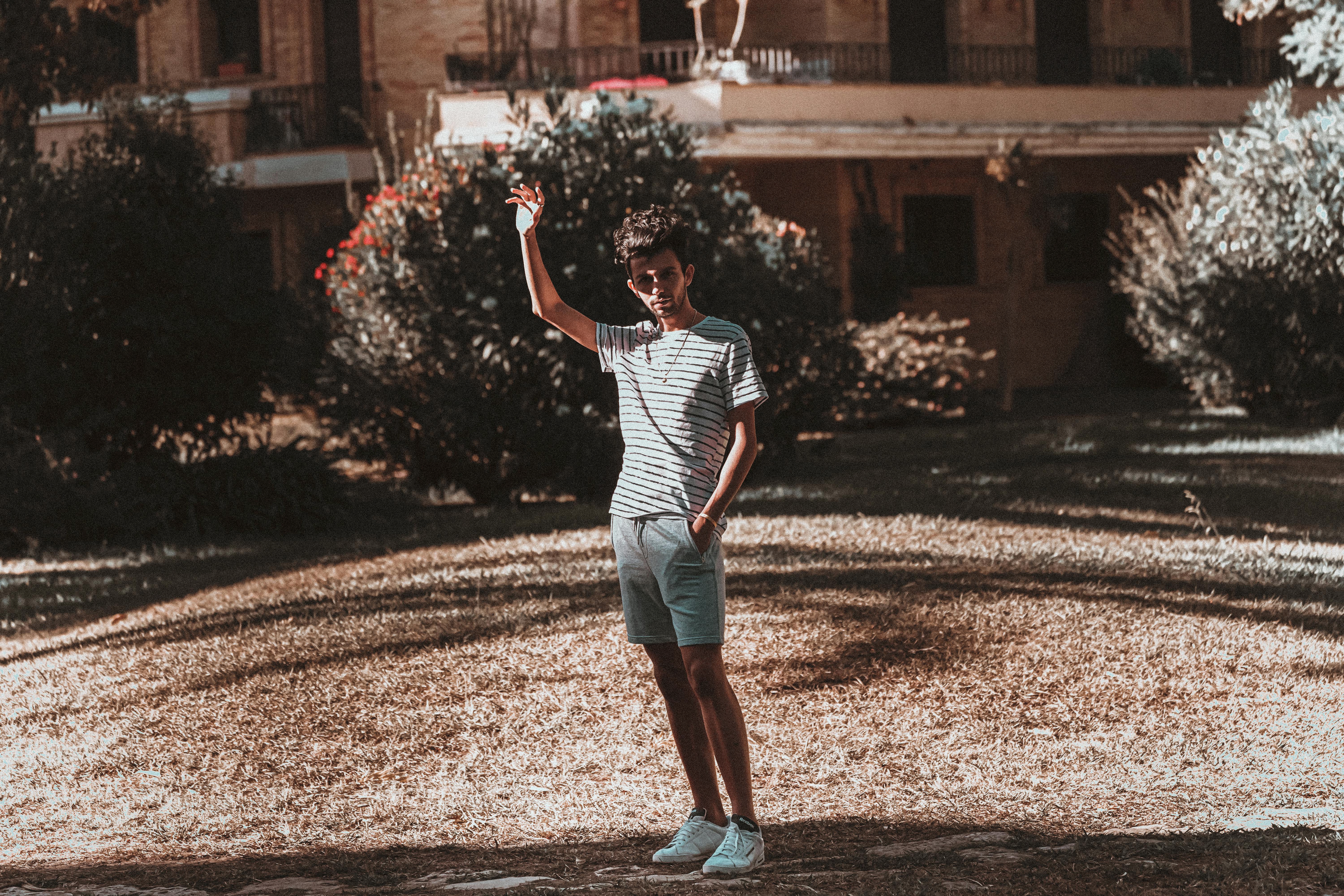 Homeowner standing in backyard assessing lawn condition in spring