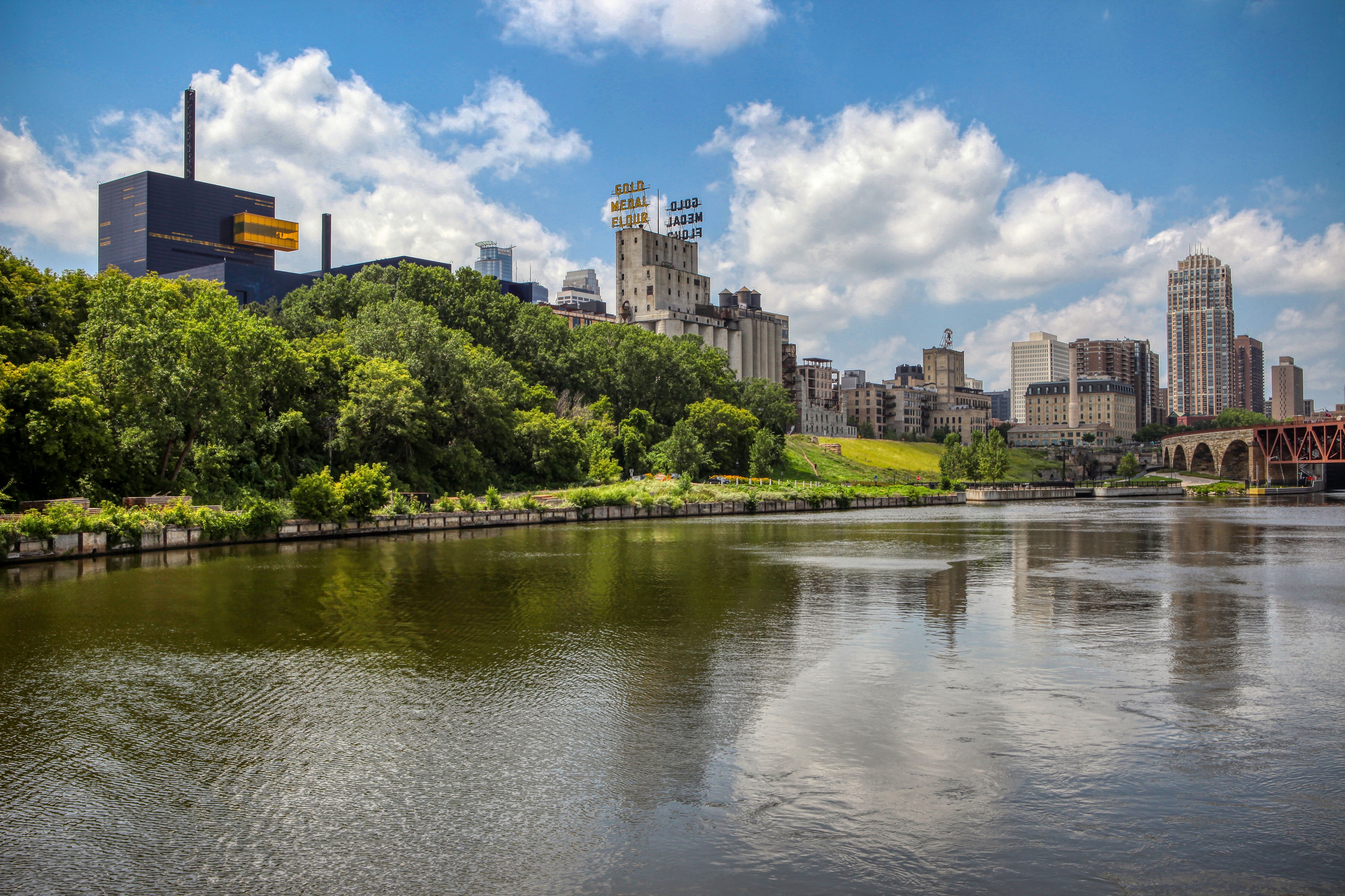 Minneapolis neighborhoods map highlighting Mill District, North Loop, Northeast, and Uptown, with transit and river trails marked - new apartments in minneapolis