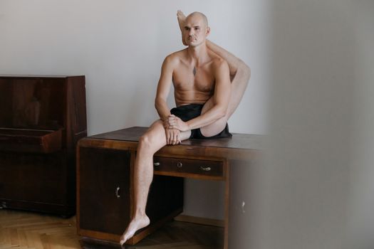 A Man's Leg on His Back while Sitting on a Wooden Cabinet