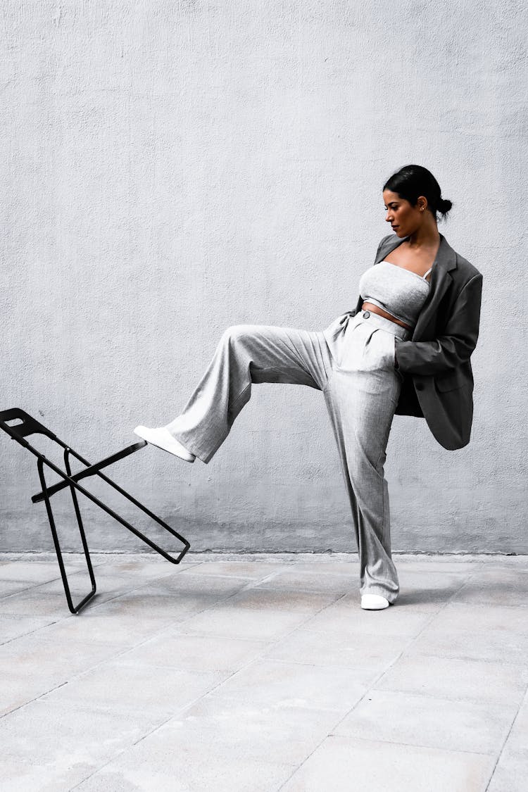 Woman In Gray Blazer Kicking The Black Chair