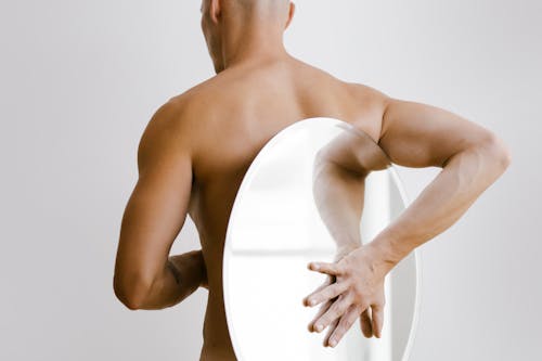 Free Topless Man Holding White Round Mirror from His Back Stock Photo