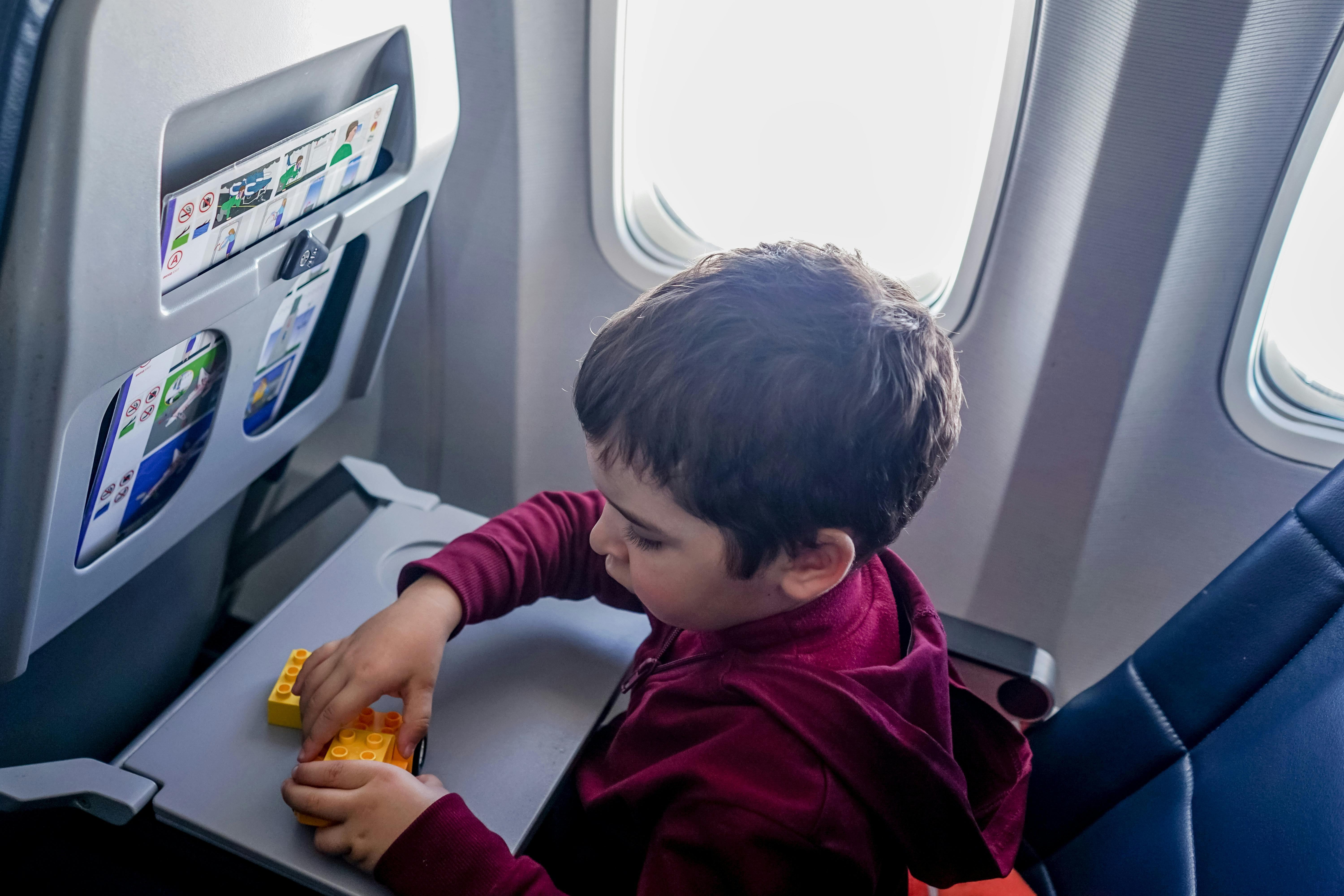 boy playing with toy on plane