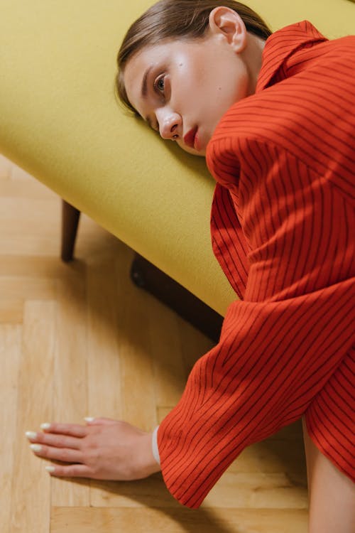 Free A Sad Woman in Red Blazer Resting on a Couch Stock Photo
