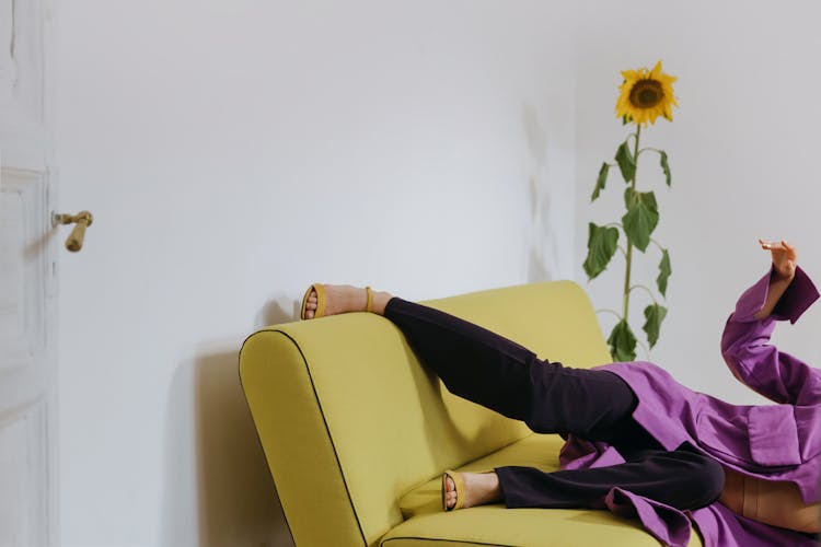 Woman In Purple Clothing Laying On A Sofa 