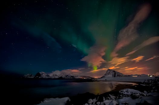 Spectacular view of the aurora borealis over snow-capped mountains in Nordland, Norway.