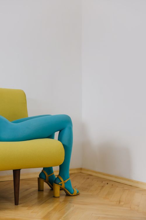 Free Vibrant blue tights on a yellow chair showcase modern fashion and style indoors. Stock Photo