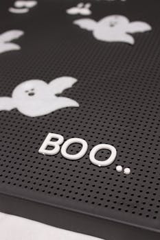 Close-up of a letter board with Halloween ghosts and 'BOO' inscription, perfect for spooky seasonal decor.