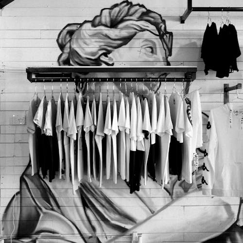 Gray Scale Photo of Clothes Hanging on Rack