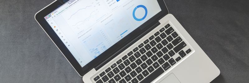 Overhead view of a laptop showing data visualizations and charts on its screen.