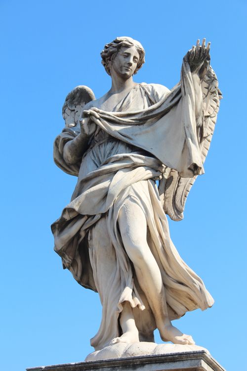 Free A stunning marble angel statue set against a clear blue sky, capturing its divine beauty. Stock Photo