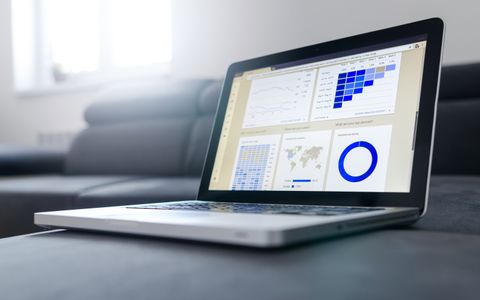 A laptop displaying data analytics charts and graphs